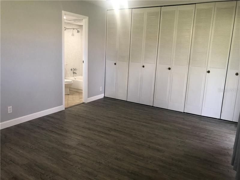 Full wall of closet with washer/dryer on left end