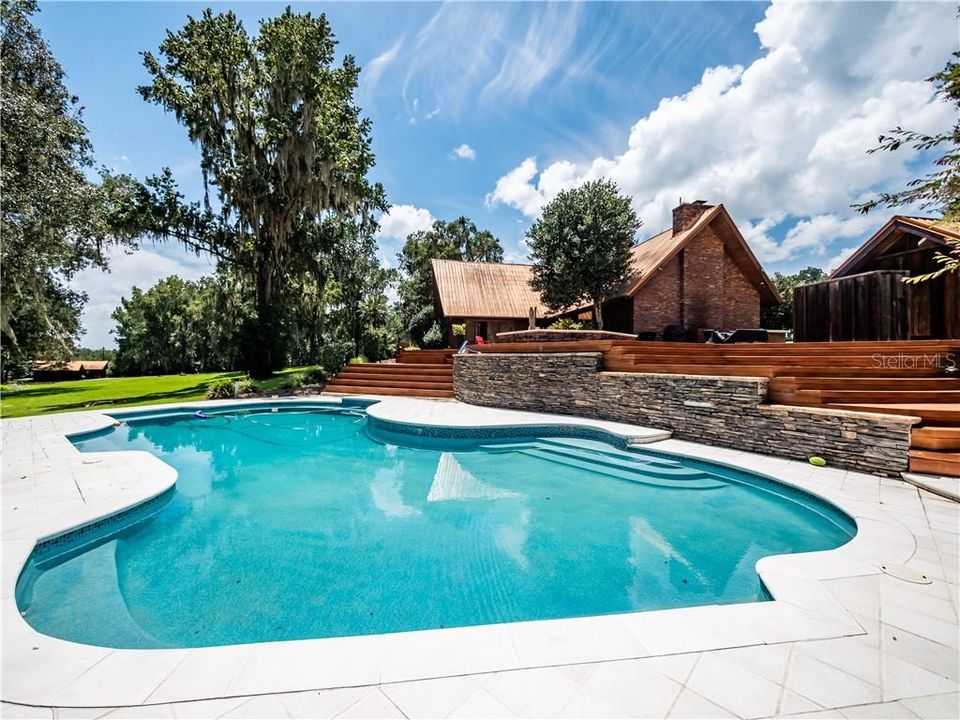 Steps on both sides of the deck lead to the pool area.