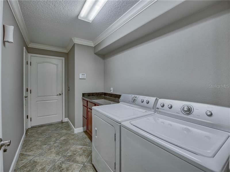 LAUNDRY ROOM WITH BUILT-IN CABINETS AND CLOSET