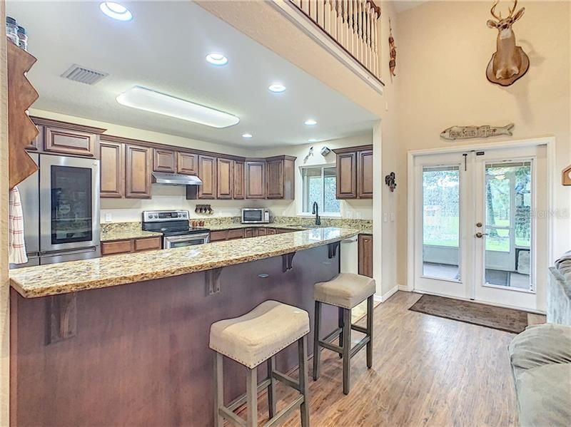 Kitchen offers a breakfast bar, wood cabinetry, granite counters and stainless steel appliances.
