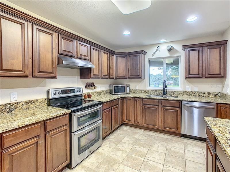 This kitchen offers amazing work space plus travertine flooring, recessed lighting and a double oven.