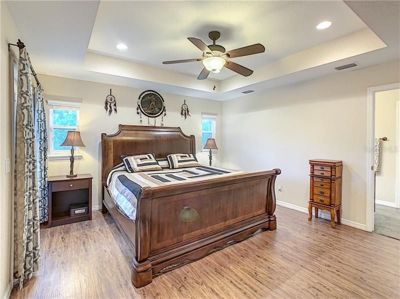 Master bedroom offers a tray ceiling, recessed lighting, lighted ceiling fan and French Doors open to the back screened in porch.