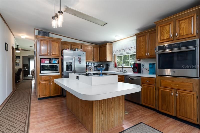The open kitchen includes huge island, good lighting, and all stainless steel appliances stay with your new home.