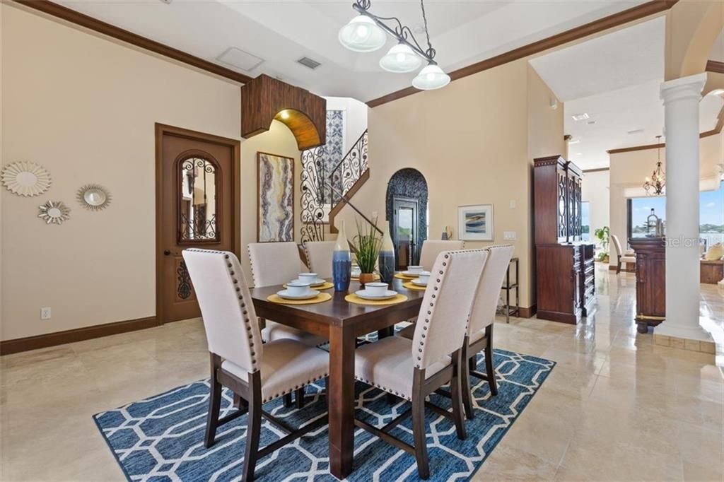 A different angel of the dining area with a view toward the bar and wrought iron stair case.