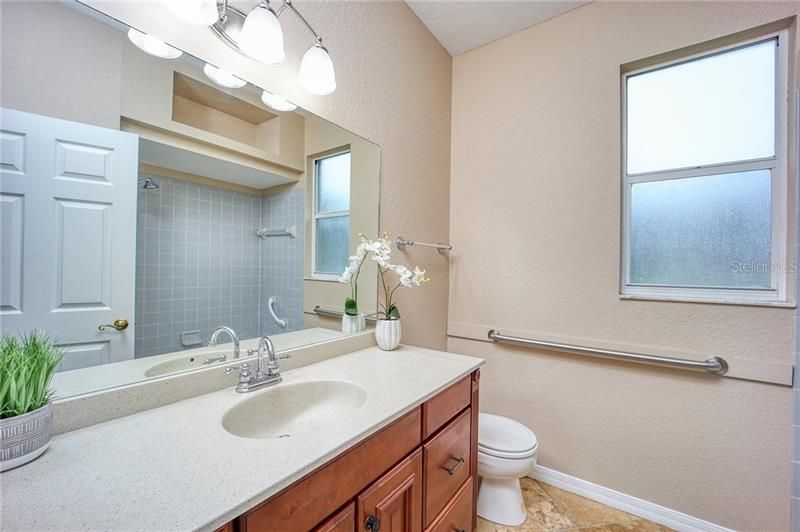 Bathroom 2 with beautiful Corian counter tops, updated light fixture and travertine flooring!