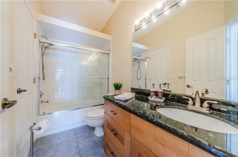 Full bathroom with two doors, one to 2nd bedroom and second into living area.