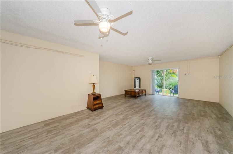 Large bonus room located on the ground floor with new durable wood grain ceramic tile which exits onto your own private patio. Perfect room for a man/child cave! Portable AC/Heater conveys.  Opposite end is door to garage.
