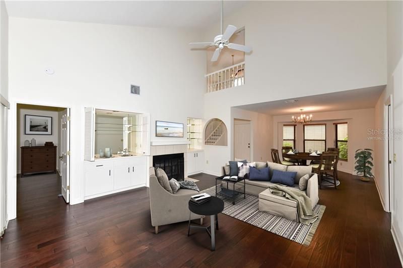 Virtually staged living room with fireplace and dining room