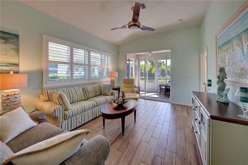 Bright and cheery living room with sliders to the lanai - just right for entertaining.  Beautiful porcelain plank style tiles flow throughout the entire home.