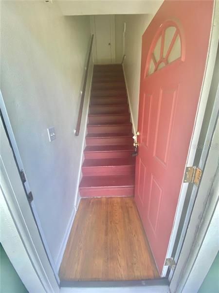 Front doorway opens to staircase leading to second floor apartment.