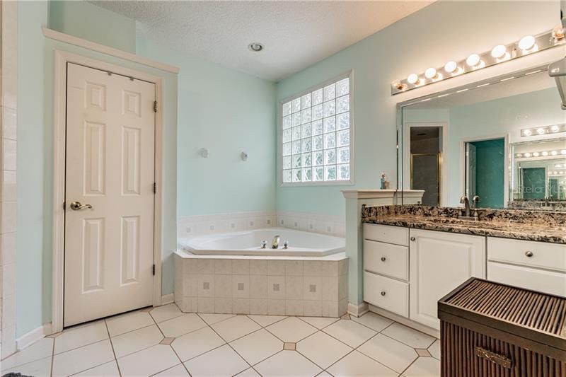 Master Bath with two separate marble top vanities, garden tub, separate shower, linen closet, separate WC