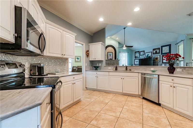 Beautiful kitchen with marble countertops, perfect backsplash and large breakfast bar.