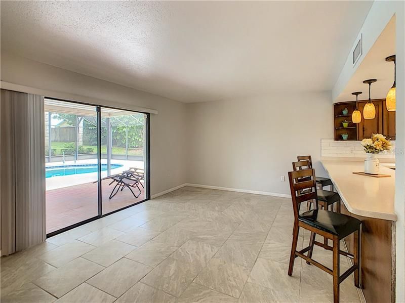 The family room has sliding glass doors that open to the screened pool cage and lanai.