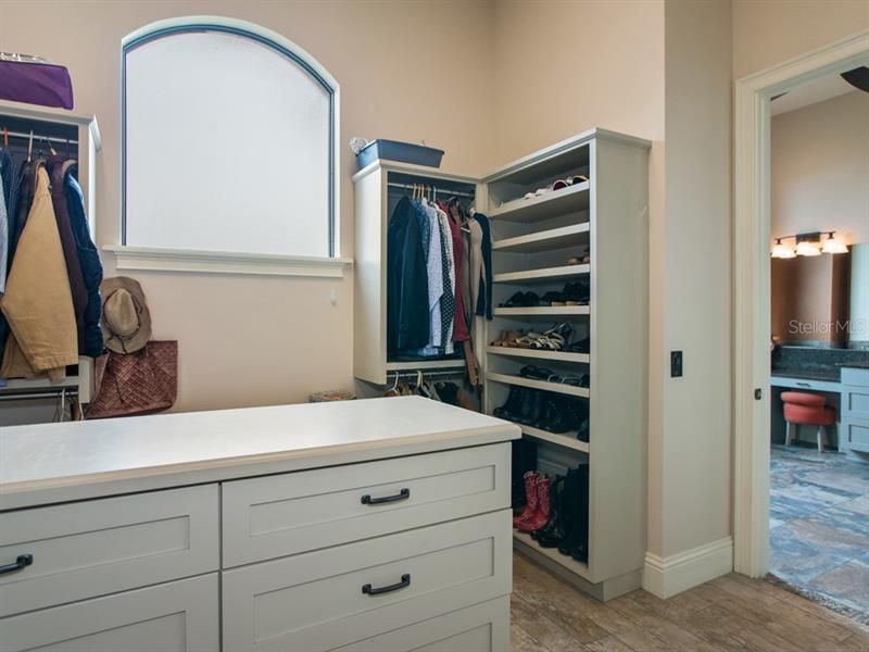 Master suite closet with custom shelving & cabinets.
