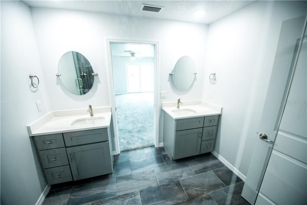 DOUBLE VANITIES WITH UNDERMOUNT SINKS IN THE FIRST MASTER BATHROOM. GORGEOUS TILE FLOORS AND SHOWER WALL TILE.