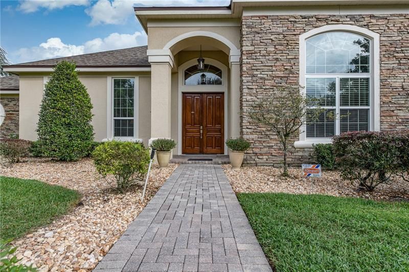 Double solid mahogany front entry doors, paver walkway and stone elevation.