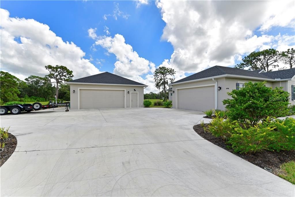 2 car attached garage. PLUS: 2 car+ workshop, air conditioned, insulated door, detached garage with gravel  parking pad to the left.