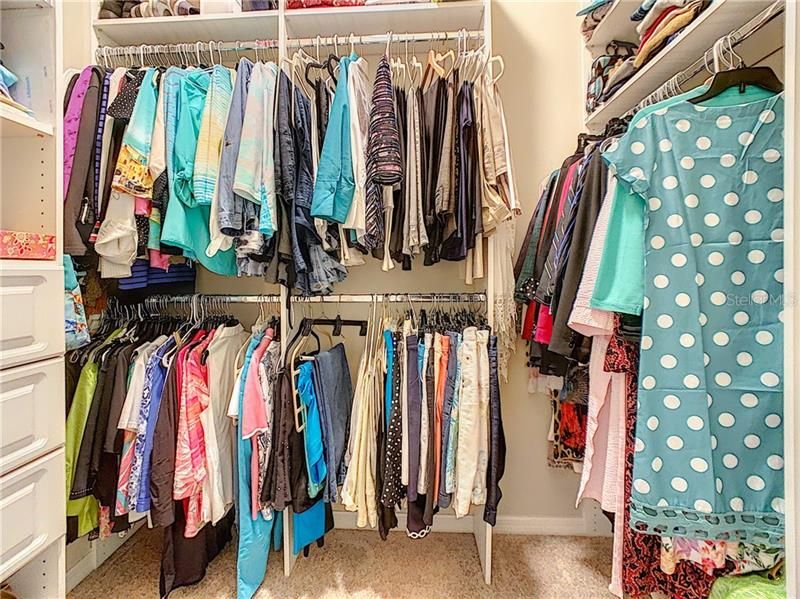 Closet with professionally organized shelves and hanging areas.