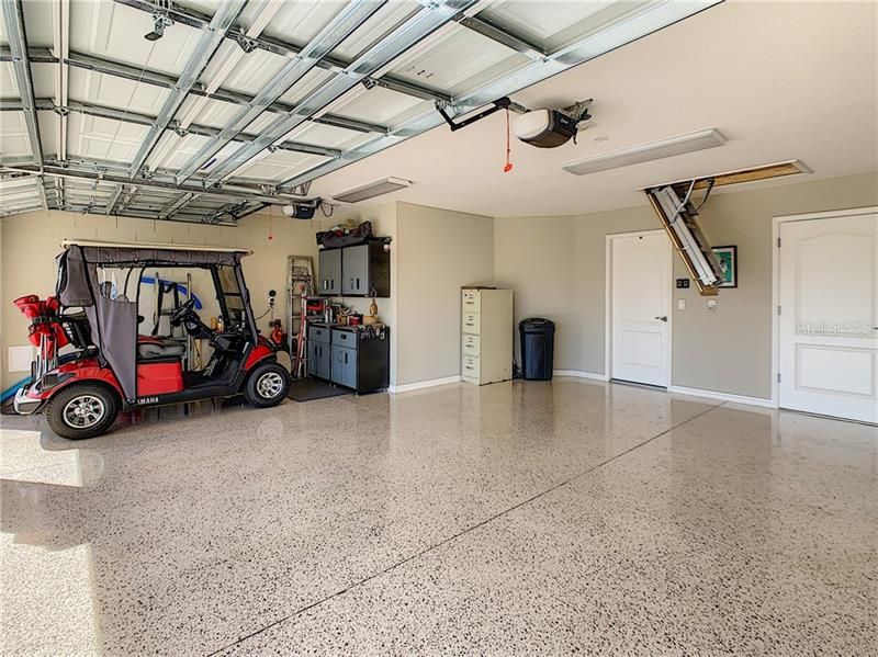 Extended garage/golf cart garage- with epoxy floors and pull down stairs for attic.