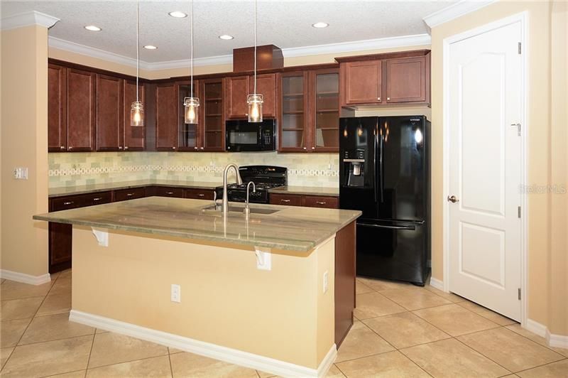 Kitchen with Upgraded Cabinetry, Granite, Backsplash, Breakfast Bar, Under Cabinet Lighting and Walk-in Pantry