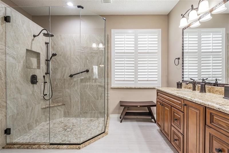 Fantastic oversized shower with built-in bench, dual showerheads and hand railing