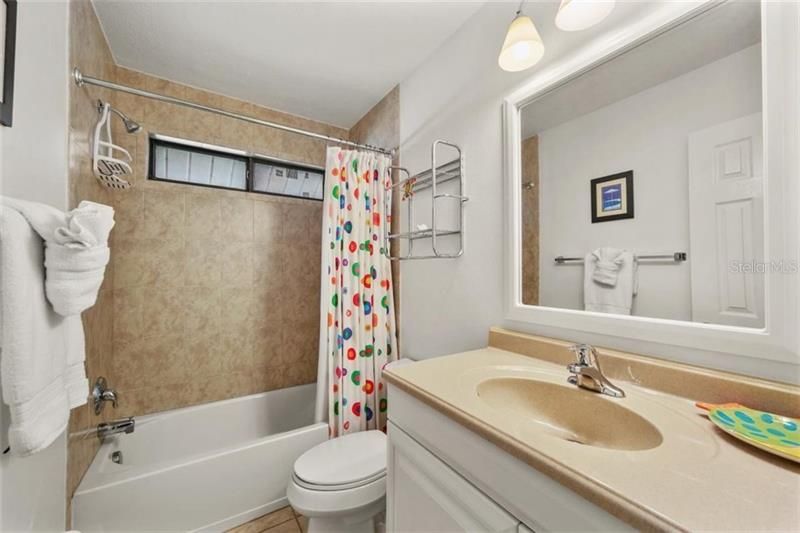 Full guest bathroom with updated shower/tub combo, newer vanity, tile floors and natural light.