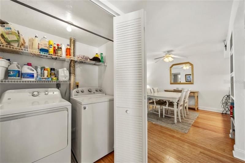 Convenient laundry closet with extra storage and hanging rack for beach and pool towels.