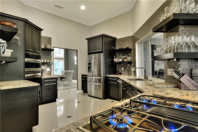 Subway tiles, porcelain floor, granite counters and gas cooktop