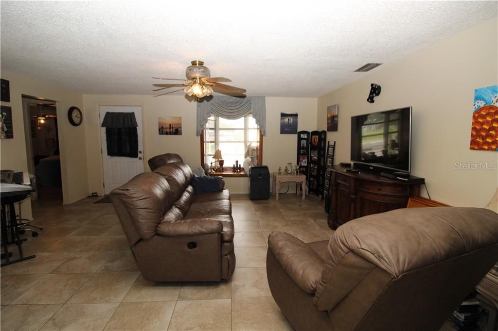 Living room has bay window in front.  Spacious room looking into the dining room.