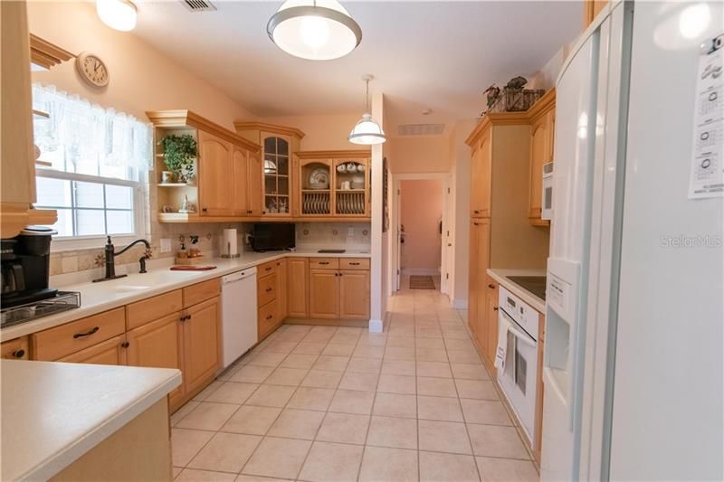 The Kitchen features solid surface counter-tops and wood cabinets with staggered tops and fronts, crown moulding, and some glass doors.