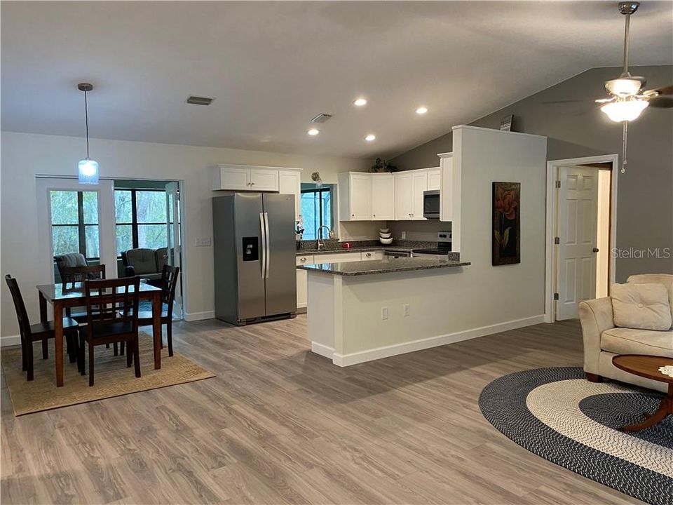 Open the front door to this beautiful, gorgeous open living/dining/kitchen area. Cathedral ceilings, luxury vinyl plank flooring thru-out the home. Thru the dining, french doors open up to the Family room over looking the pool area and the water.