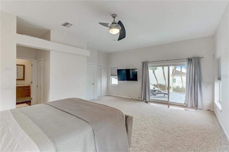 The master bedroom features a private rooftop deck with views of the canal and Sarasota Bay.