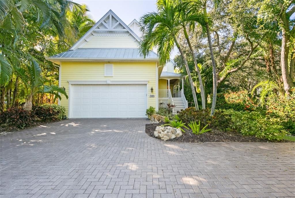 Front of house, nestled in lush tropical landscaping