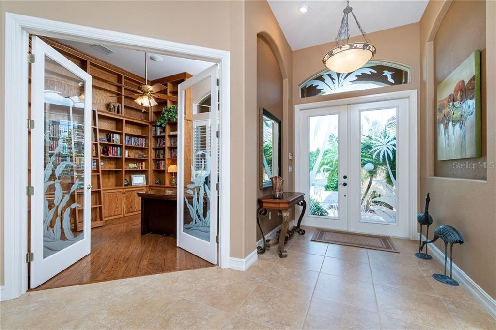 Charming etched double doors lead to the impressive library.