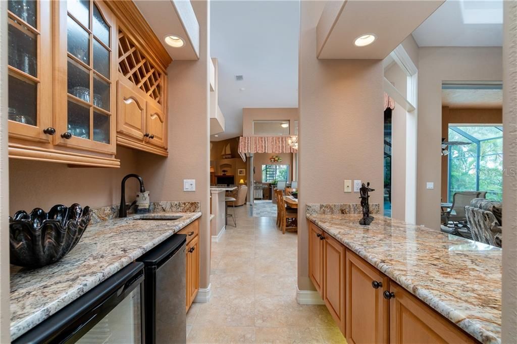 Stunning granite tops, wine chiller and bar refrigerator, and built-in wine rack are features of this great entertaining space.