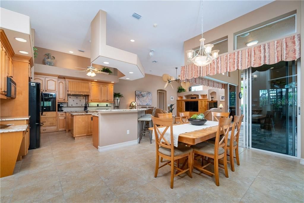 Eat-in kitchen enjoys tranquil pool views through 90-degree seamless sliding doors.