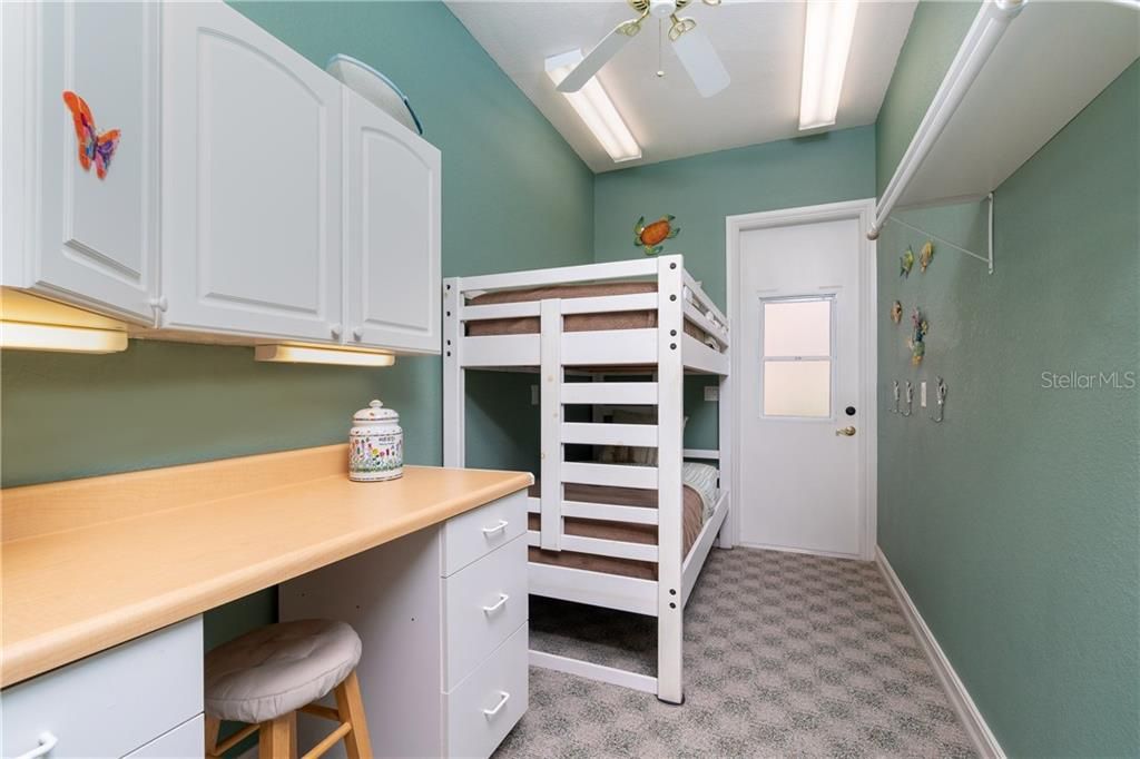 This craft or hobby room enjoys built-in desk and storage