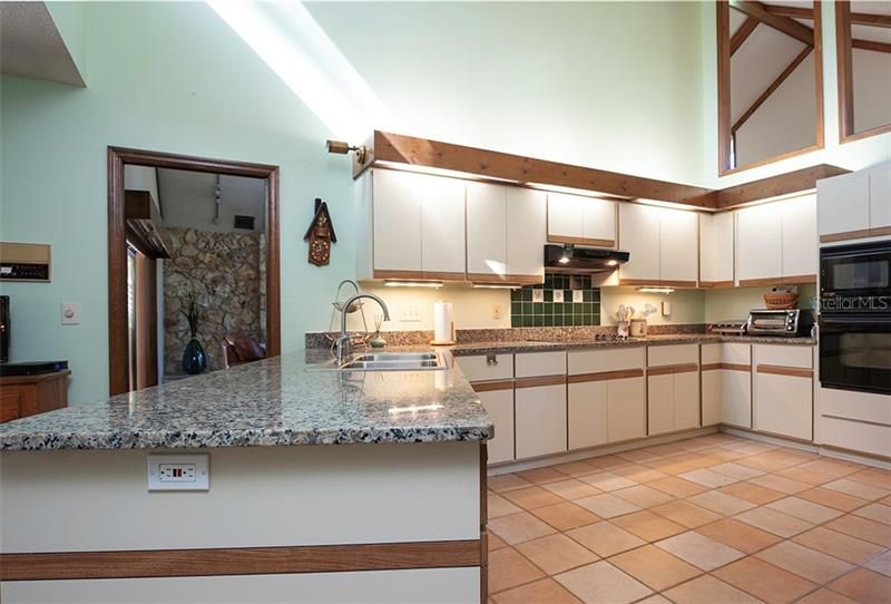 The kitchen has granite counter tops, cooktop and double ovens with a view to the pool!