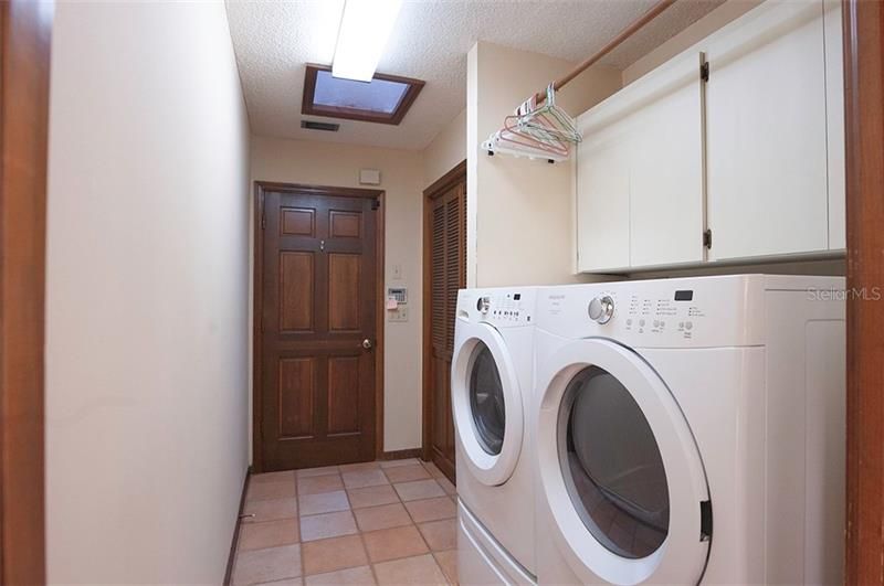 The laundry room washer & dryer convey, has cabinets and a huge closet!