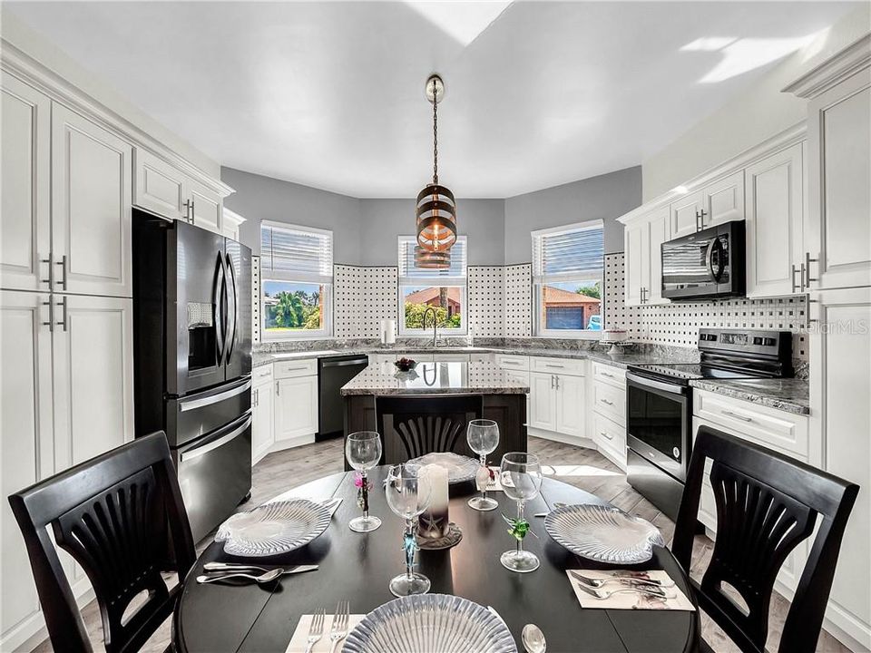 Kitchen with beautiful granite countertops & an island with power underneath for extra outlets.