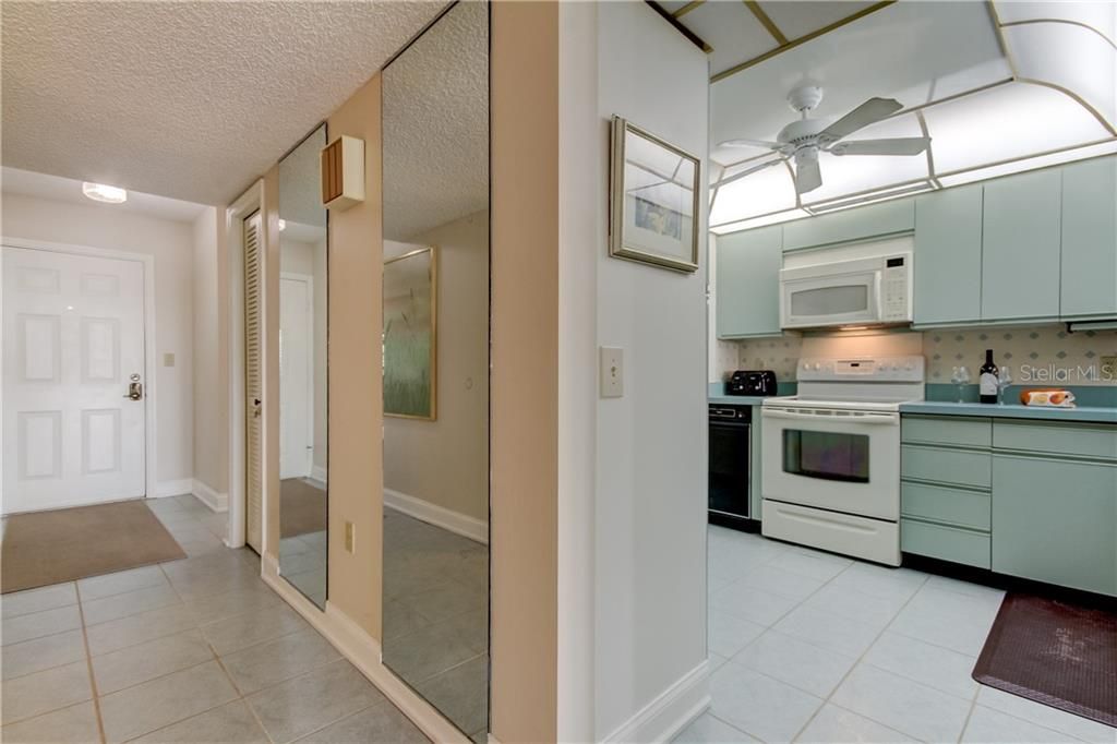 Entry door to the unit and a view of the kitchen