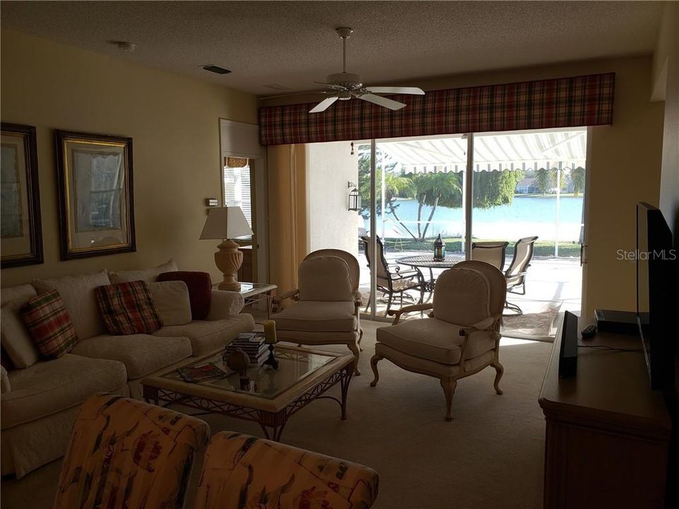 View the serene lake through the sliding doors. Note retractable awning on the lanai.