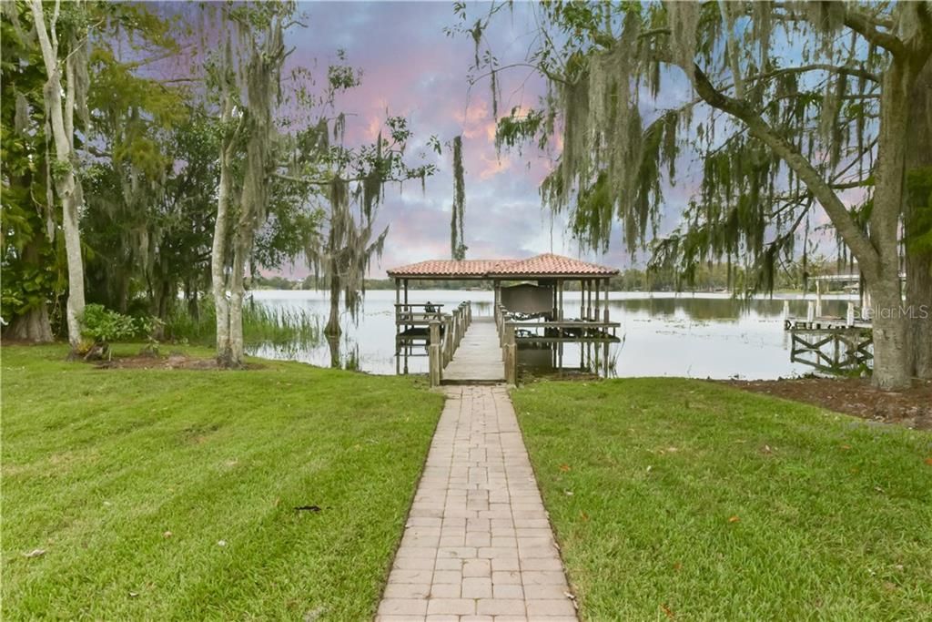 A brick paver pathway leads you to your private dock and boathouse on private Little Lake Howell.