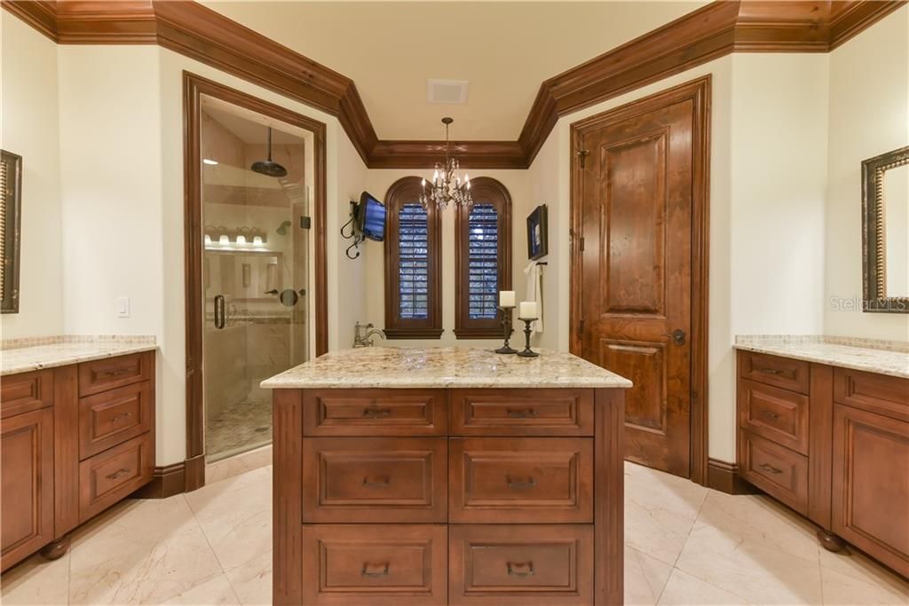 Master bathroom includes dual vanities, dressing island, clawfoot tub, rounded windows, plantation shutters and spa-like shower.