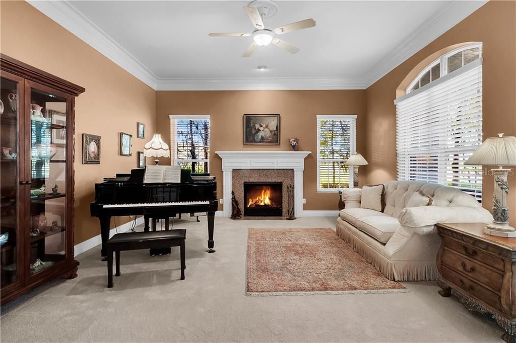 The formal living room includes crown molding, a fireplace and built-in shelving.