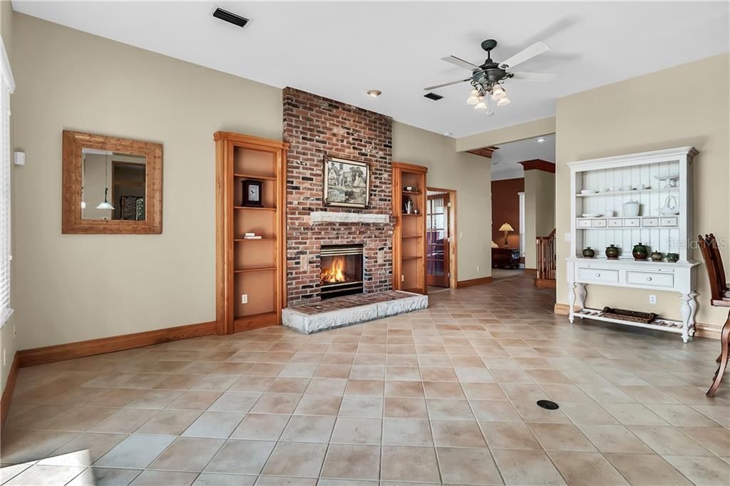 The spacious family room is adorned with a brick floor to ceiling fireplace with a custom limestone mantle.