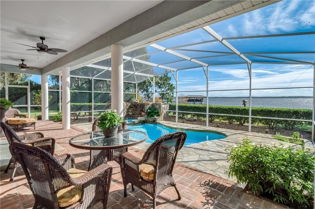 Entertaining has never been easier out back on the brick lanai leading to the custom pool and spa adorned with a rock formation overlooking a huge yard with a conservation easement and unspoiled views of the lake.