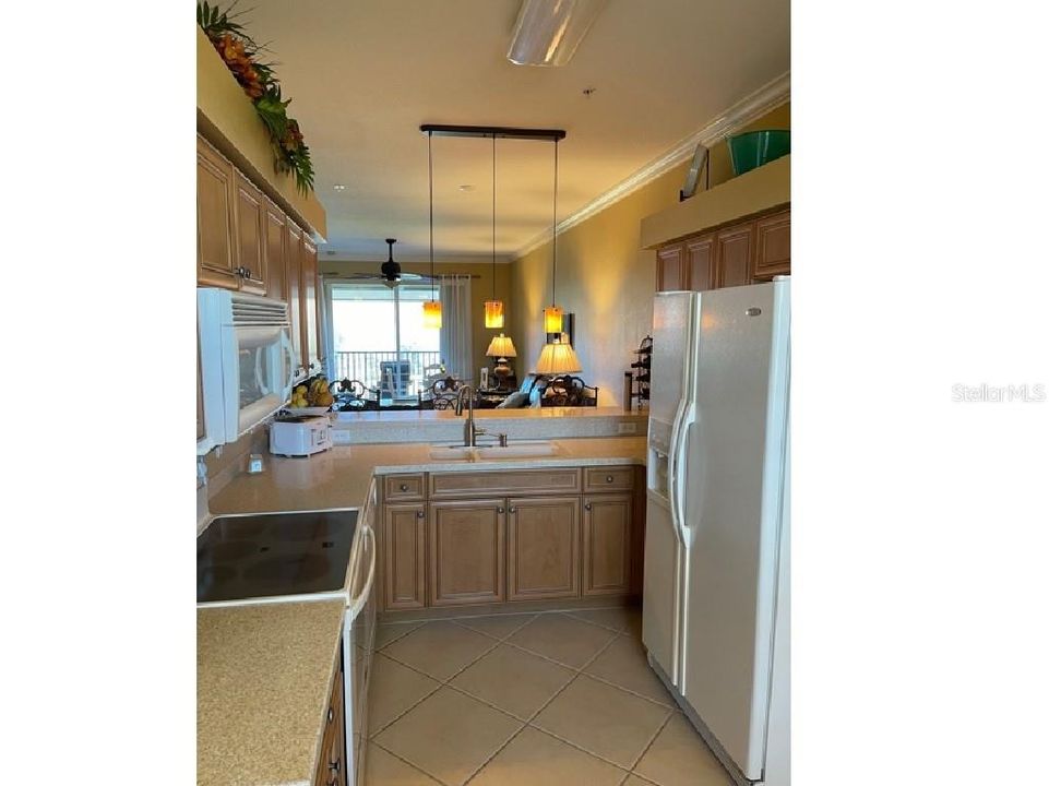 Glass top range and double door refrigerator in kitchen