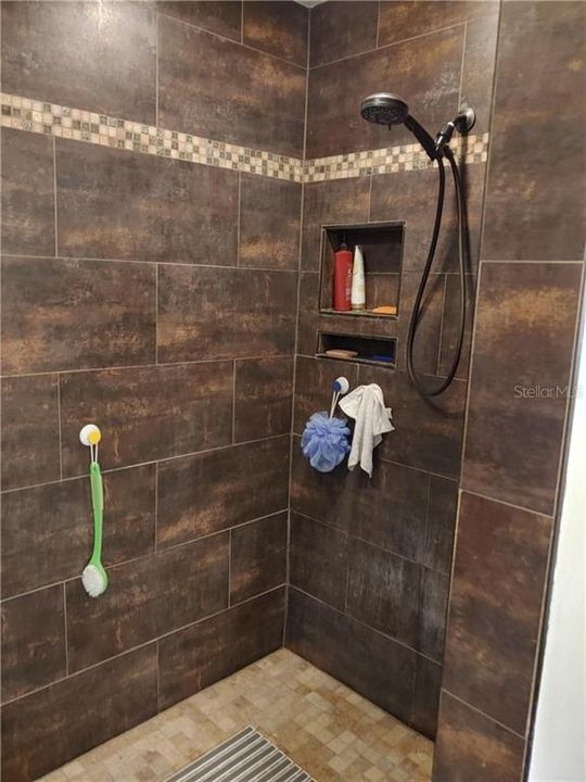 Beautifully done shower.  Features a seat on the other end.  Nice alcoves for soaps, etc.