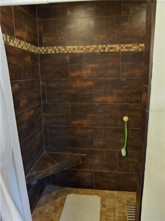 Shows seat in master shower.